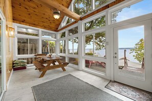 A spacious room with large windows, a wooden table, and a view of the lake. - Pine Ridge:"A True Gem" (Geneva)