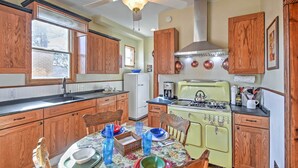 Una cucina con mobili in legno, un fornello e un tavolo da pranzo apparecchiato.