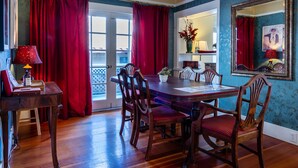 A dining area with a wooden table and chairs, a red curtain, and a mirror on the wall. - 1916 Craftsman + Firepit | Walk Downtown | Poe House (Paso Robles)