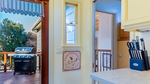 A kitchen with a wooden deck, a grill, and a vintage sign advertising farm fresh eggs.