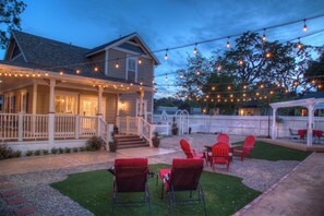 A house with a porch, outdoor seating, and string lights.