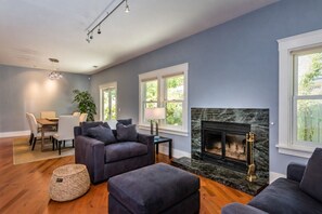 Un salon avec une cheminée, un coin repas et un espace détente.