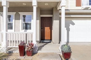 A house with a front porch, a brown door, and potted plants. - BBQ Patio + Chef's Kitchen | Paso Robles Wine Country | Sunset Summit (Paso Robles)