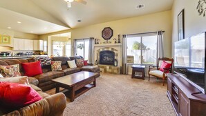 A living room with a fireplace, a sofa set, a coffee table, and a television. - Fenced BBQ Yard + Game Table | Paso Robles | Peace of Mind (Paso Robles)