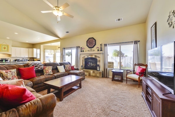 A living room with a fireplace, a sofa set, a coffee table, and a television.