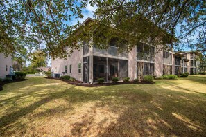A two-story building with a covered porch and a lawn in front. - TB 13D 3Br/3Bath unit super nice with great view on golf course (Pawleys)