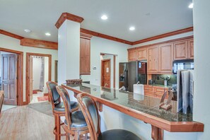 Una cocina con armarios de madera, encimera de granito y refrigerador empotrado.