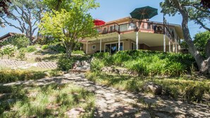 A two-story house with a covered patio and a stone pathway leading to the entrance.