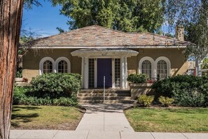 Une maison à deux étages avec une façade marron, une porte d’entrée bleu foncé et le numéro « 623 » au-dessus de l’entrée.