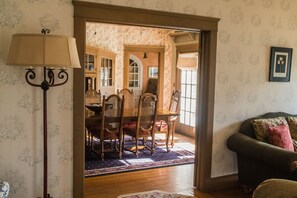 Un coin repas avec une table et des chaises en bois, un lampadaire et un tapis à motifs.