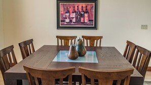Un tavolo da pranzo con quattro sedie, un'opera d'arte incorniciata sopra e due vasi decorativi.