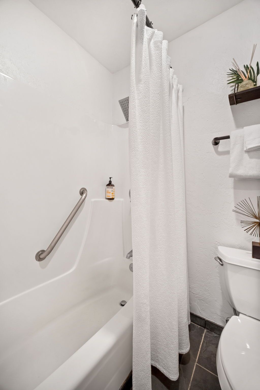 Ein Badezimmer mit einer weißen Badewanne, einer weißen Toilette und einer Duschvorhang.