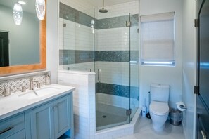 Ein modernes Badezimmer mit Duschkabine, Toilette und Waschtisch mit Spiegel.