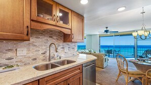 A kitchen with stone backsplash, wooden cabinets, and a dishwasher.