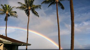 Une maison avec vue sur l’océan et un arc-en-ciel.