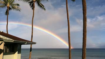 A house with a view of the ocean and a rainbow.