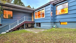 A two-story house with a covered porch, a staircase, and a well-maintained lawn. - Downtown Anchorage Home, 1 Block to Coastal Trail! (Anchorage)
