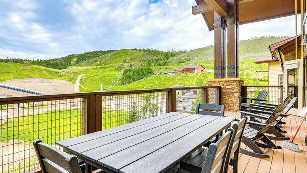A covered outdoor seating area with a view of a green landscape and hills. - Ski-In/Ski-Out Granby Penthouse w/ Mountain Views! (Granby)