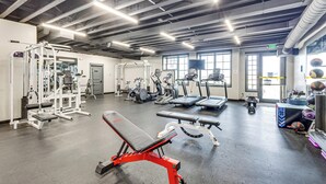 A gym with various exercise equipment, a bench press, treadmills, and a weight rack. - Granby Home w/ Hot Tub + Ski, Golf & Pool Access (Granby)