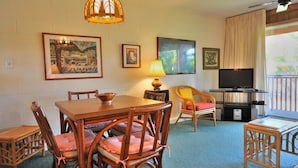 Una habitación acogedora con una mesa de comedor, sillas, un televisor y obras de arte en las paredes.