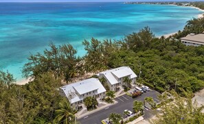 Une propriété située sur la côte, comprenant un bâtiment à deux étages, un espace de stationnement et une vue sur l’océan.
