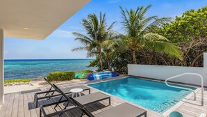 Un espace piscine comprenant des chaises longues, une petite piscine et une vue sur l’océan.