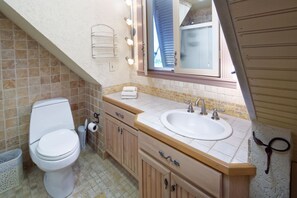 Une salle de bain équipée de toilettes, d’un lavabo et d’un meuble-lavabo.