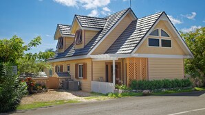 Ein zweistöckiges Haus mit Satteldach, einer Veranda und einem kleinen Garten.