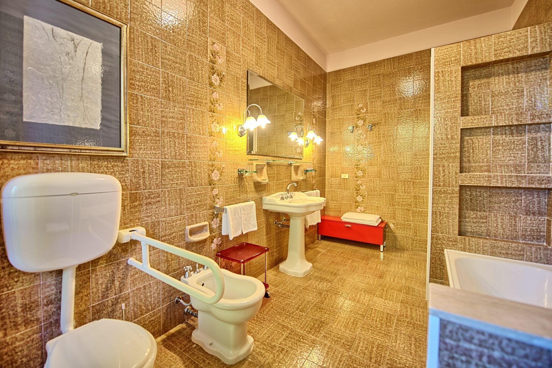A bathroom with a toilet, bidet, sink, and bathtub.