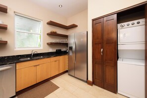 Eine moderne Küche mit einem Edelstahl-Kühlschrank, einem Einbauofen und einem Geschirrspüler.