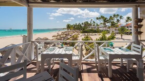Un restaurant situé en bord de mer, avec une terrasse et une vue sur la plage et l’océan.