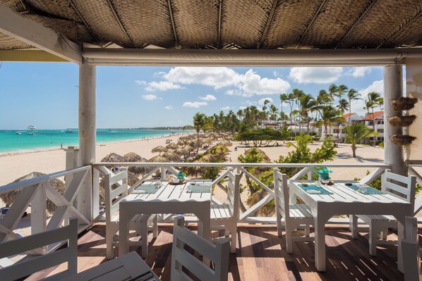 Un restaurante frente a la playa con terraza y vistas al mar.