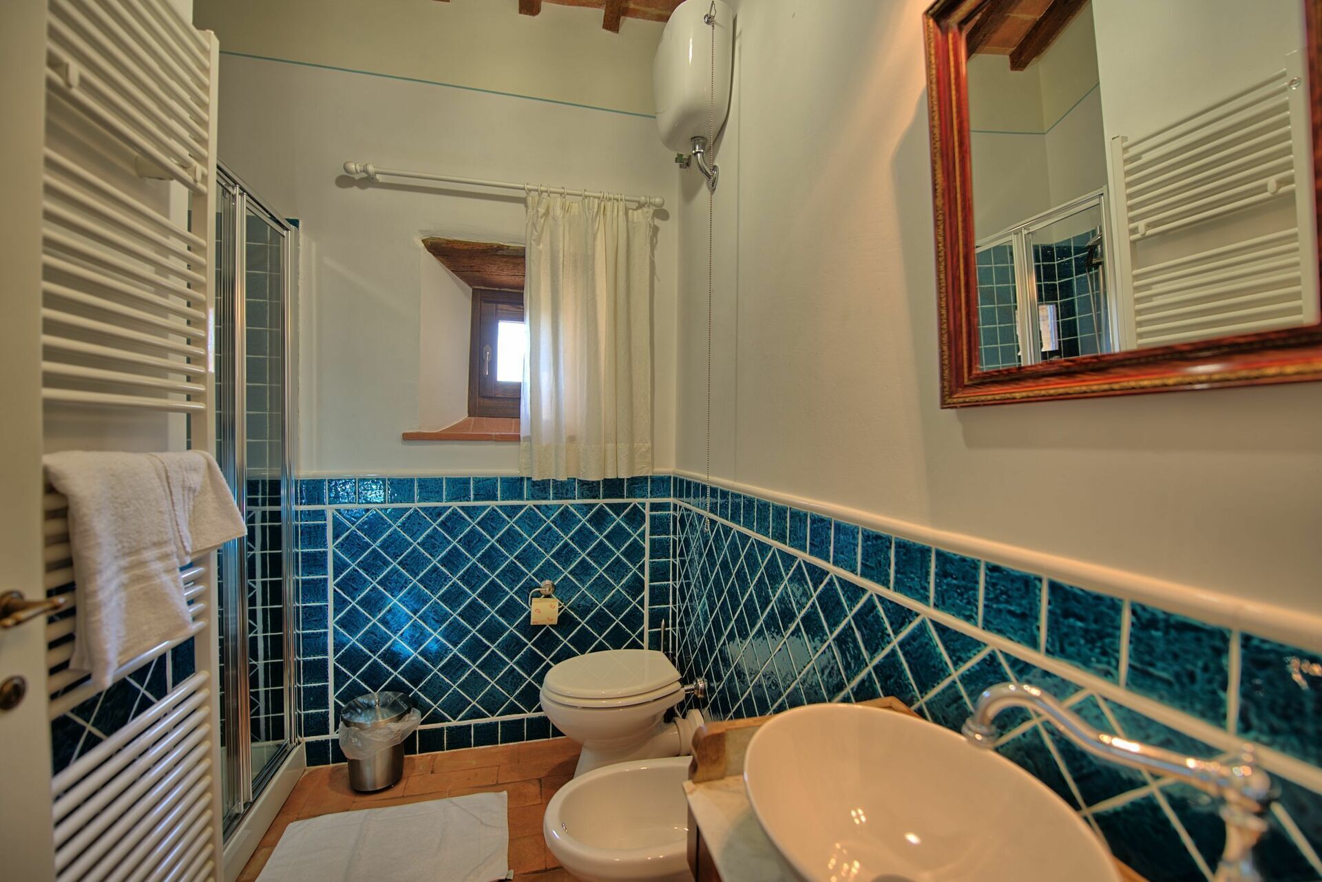 A bathroom with a toilet, sink, and a shower area.