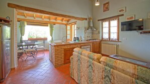 Una cucina accogliente con zona pranzo, travi in legno e un divano.