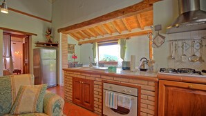 Una cucina con isola centrale, mobili in legno, forno integrato e piano cottura a gas.