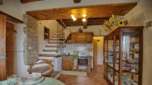 Eine rustikale Küche mit Steinwand, Holzschränken und einem eingebauten Backofen.