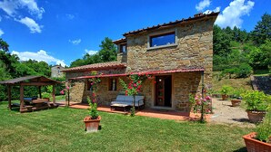 A stone house with a patio, outdoor seating, and potted plants. - Villa Margherita Uno - Holiday Villa Rental with swimming pool in Cortona, Tuscany (Cortona)