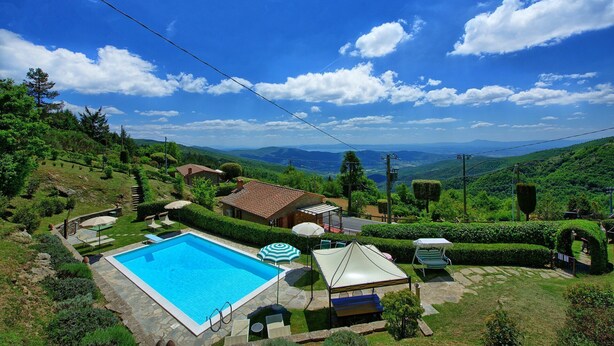 A pool area with a clear view of the surrounding landscape, including hills and a distant mountain range. - Villa Portole Uno - Holiday Villa Rental in Cortona (Tornia)