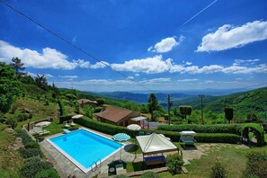 A pool area with a clear view of the surrounding landscape, including hills and a distant mountain range. - Villa Portole Uno by PosarelliVillas (Tornia)