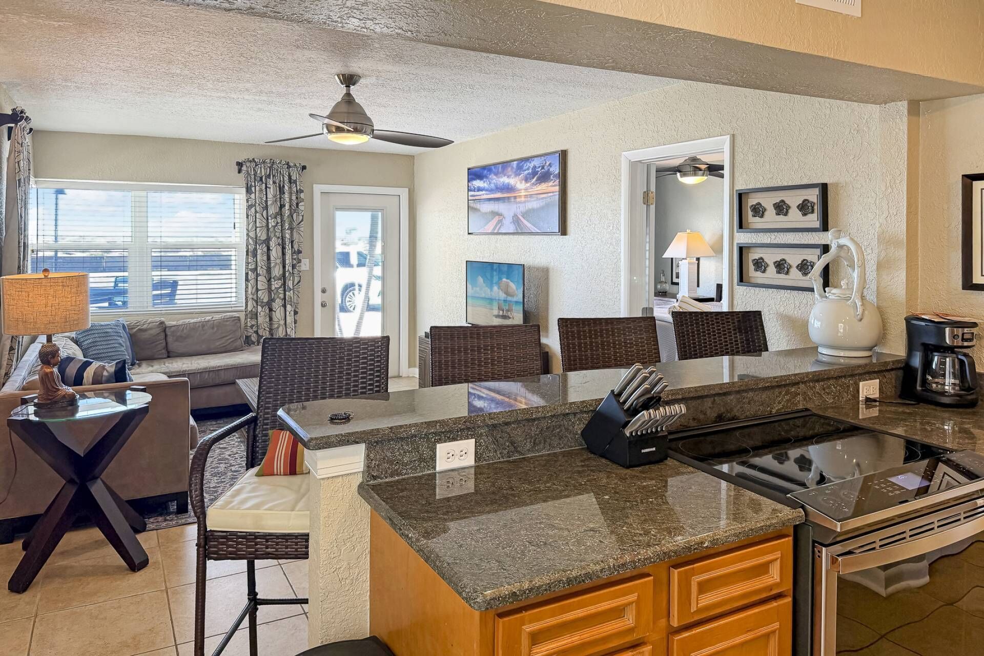 A modern kitchen with a granite countertop, a built-in stove, and a coffee maker.