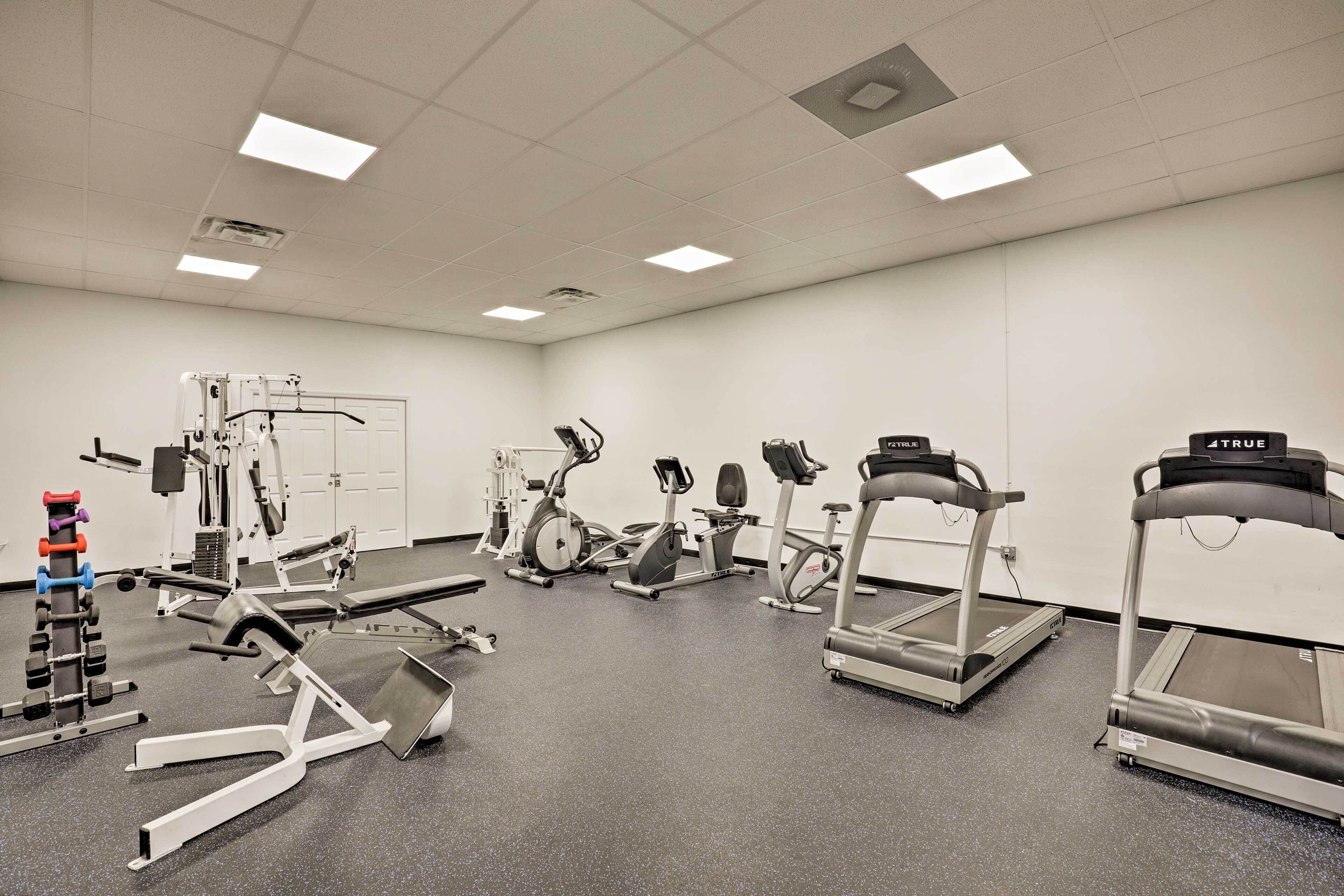 Ein Fitnessstudio mit verschiedenen Trainingsgeräten, darunter Laufbänder, Ergometer und Kraftgeräte.