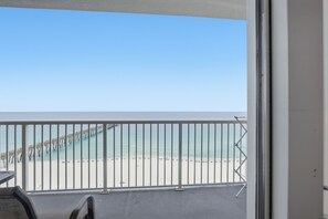 A balcony with a view of a beach and pier.