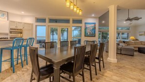 A spacious kitchen with a large dining table, blue chairs, and a built-in oven. - Manatee Manor: Exclusive Beachfront Retreat with Gulf Views (North Captiva)