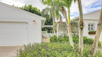 Surrounded by lush greenery, this property offers a serene and garden with a variety of plants and a palm tree.
