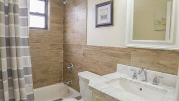 Un baño con ducha, inodoro y lavamanos.