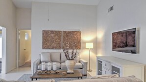 Una sala de estar moderna con un sofá, una mesa de centro y objetos decorativos.