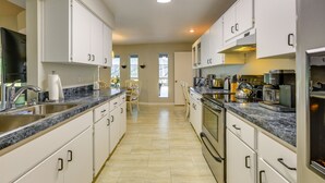 A modern kitchen with white cabinets, granite countertops, and stainless steel appliances. - 3 Mi to Dunnellon Historic District: Home w/ Lanai (Dunnellon)