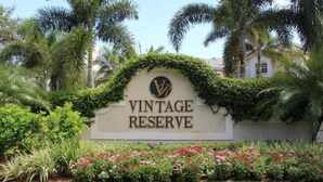 Cartell de "VINTAGE RESERVE" amb un logotip, envoltat de vegetació exuberanta i plantes florents.