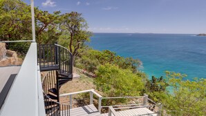 Una proprietà sul lungomare con terrazza in legno, scala a chiocciola e vista mare.