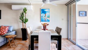 A dining area with a table, chairs, a ceiling fan, and a painting on the wall. - Breezy Rio Grande Getaway w/ Pristine Ocean Views! (Rio Grande)